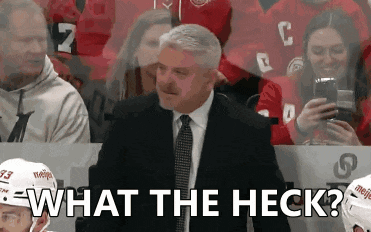 a man in a suit and tie says what the heck in front of a crowd