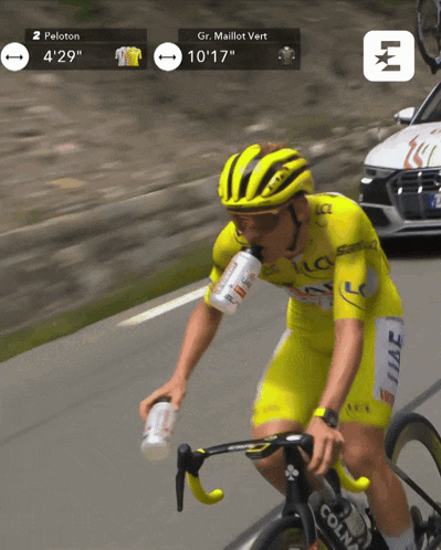 a man riding a bike with a bottle in his mouth and a peloton sign behind him