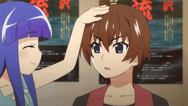 a girl touches a boy 's head in front of a poster with chinese characters