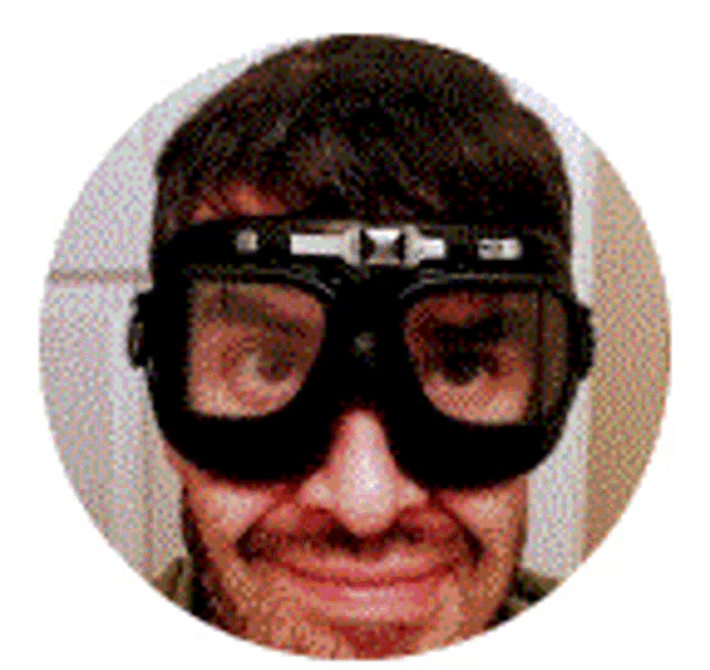 a man wearing a pair of goggles is smiling for the camera