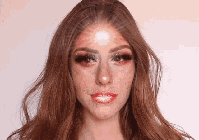 a woman with red hair and freckles is wearing makeup