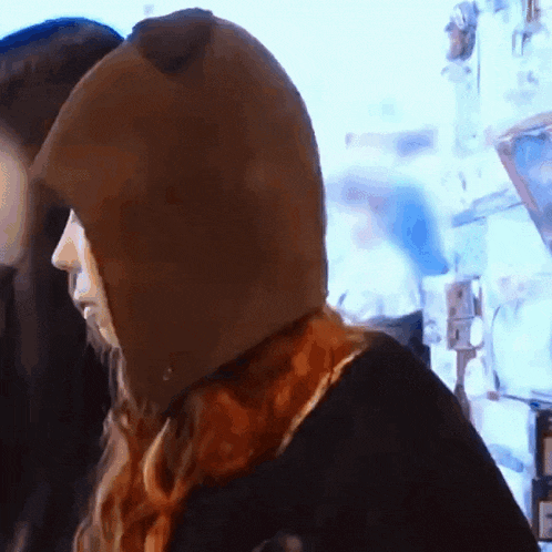 a woman wearing a brown hooded hat with ears
