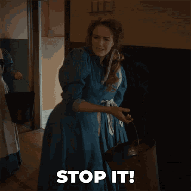 a woman in a blue dress holds a bucket and says stop it
