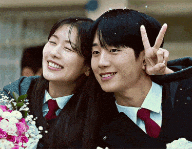 a man giving a peace sign next to a woman