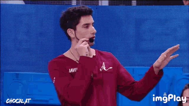 a man wearing a red shirt that says javie on it
