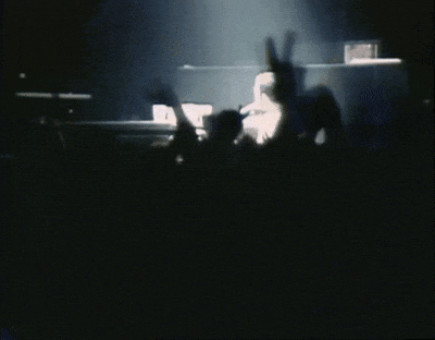 a crowd of people with their hands in the air