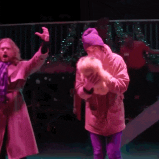 a man in a trench coat holds a stuffed animal in his hand