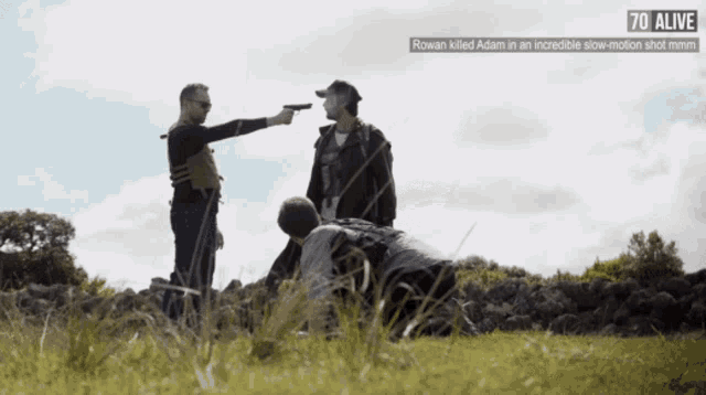 a man is pointing a gun at another man with the words 70 alive above him