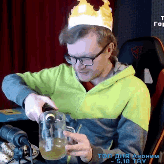 a man wearing a crown is pouring liquid into a mug
