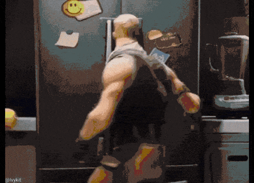 a man standing in front of a refrigerator with a smiley face on the door