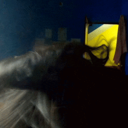 a blurry picture of a person in a dark room with a yellow light in the corner