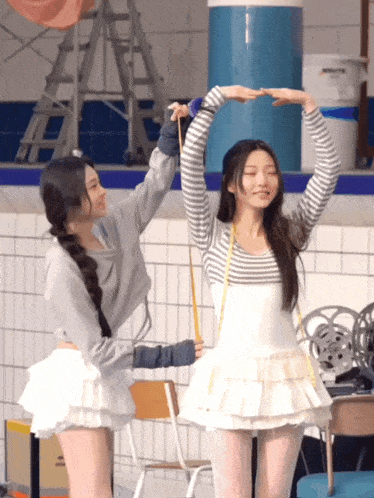 two girls are standing next to each other and one of them is measuring the other 's height