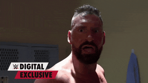 a man with a beard is standing in a locker room with a digital exclusive sign behind him