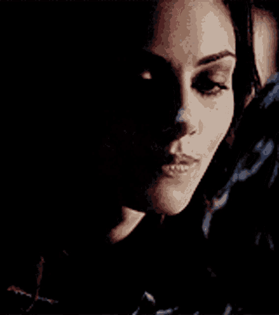 a woman 's face is shown in a dark room