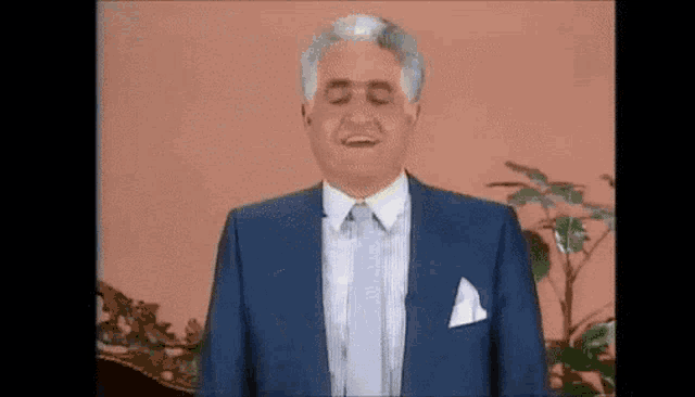 a man in a blue suit and white shirt is smiling .