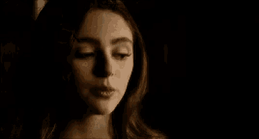 a close up of a woman 's face with a dark background .