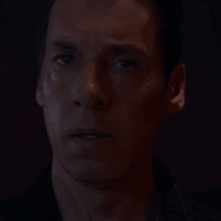 a man 's face is shown in a dark room