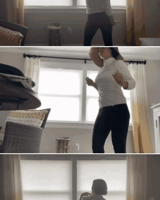a woman in a white shirt is dancing in front of a window in a living room
