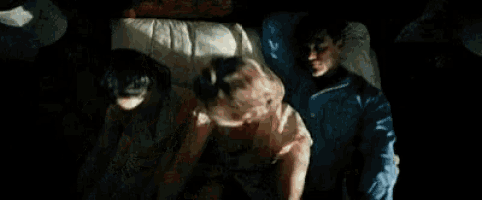a man and a woman are sleeping in a bed with a dog .