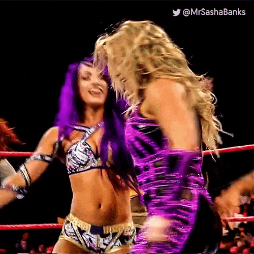 two women are wrestling in a ring and one is wearing a purple outfit