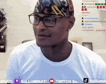 a man wearing glasses and a bandana is sitting in front of a twitch so banner