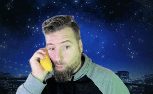 a man with a beard is holding a lemon in front of his mouth