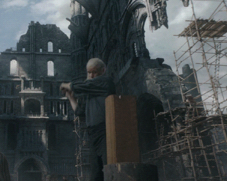 a man is standing in front of a building with scaffolding in front of it