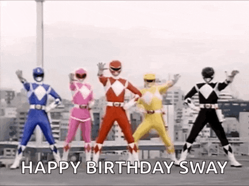 a group of power rangers are standing next to each other on top of a building .