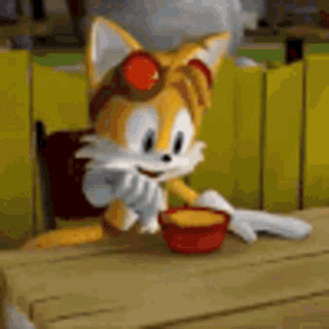 tails from sonic the hedgehog is sitting at a table with a bowl of sauce .