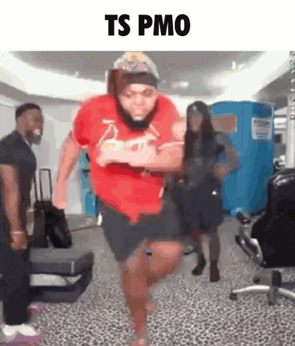 a man in a red shirt is running in a room with other people and the words ts pmo above him