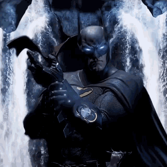 a man in a batman costume stands in front of a waterfall holding a hammer