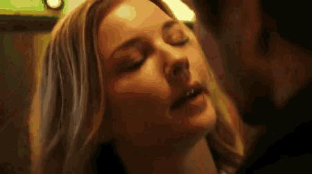 a man and a woman are kissing in a dark room .