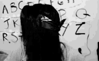 a girl is standing in front of a white board with the letters written on it