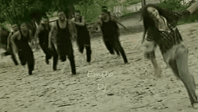 a group of people running on a dirt road with emilio dj written on the bottom right