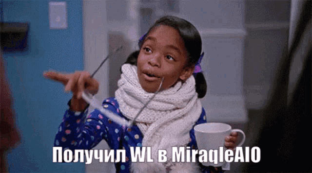 a little girl with a scarf around her neck is holding a cup and pointing at something in a foreign language