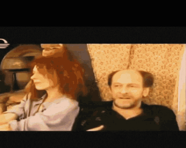a man and a woman are sitting next to each other on a couch