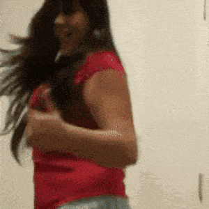 a woman in a red shirt is dancing in a room