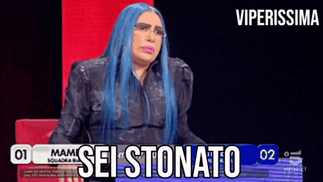 a woman with blue hair is sitting in front of a sign that says sei stomato
