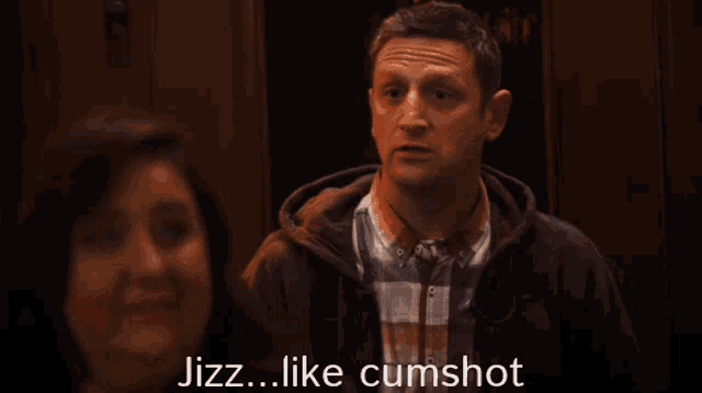 a man in a plaid shirt says jizz like cumshot in front of a woman