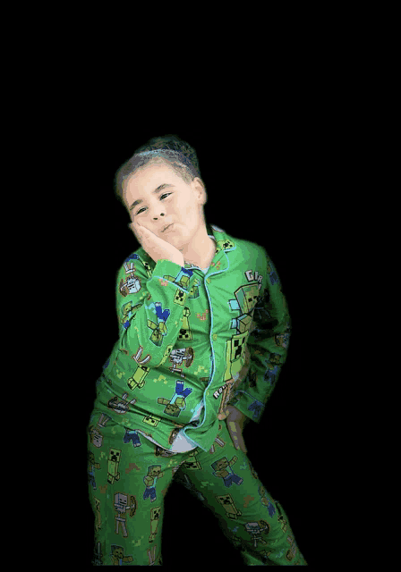 a young girl wearing a green pajama set with minecraft characters on it