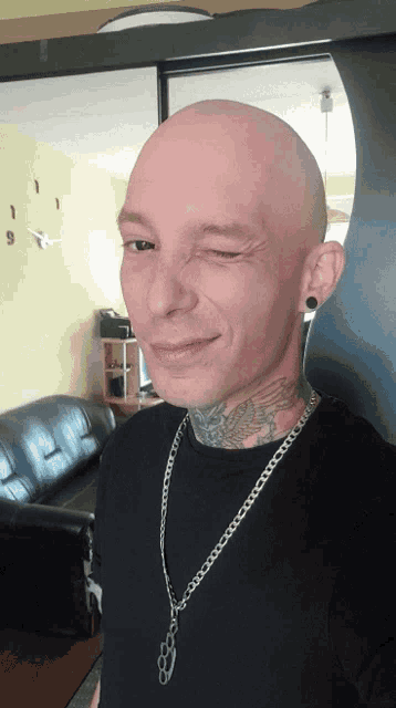 a man with a tattoo on his neck is making a wink