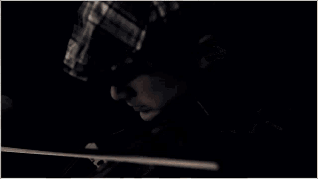 a close up of a person playing a violin with a black background