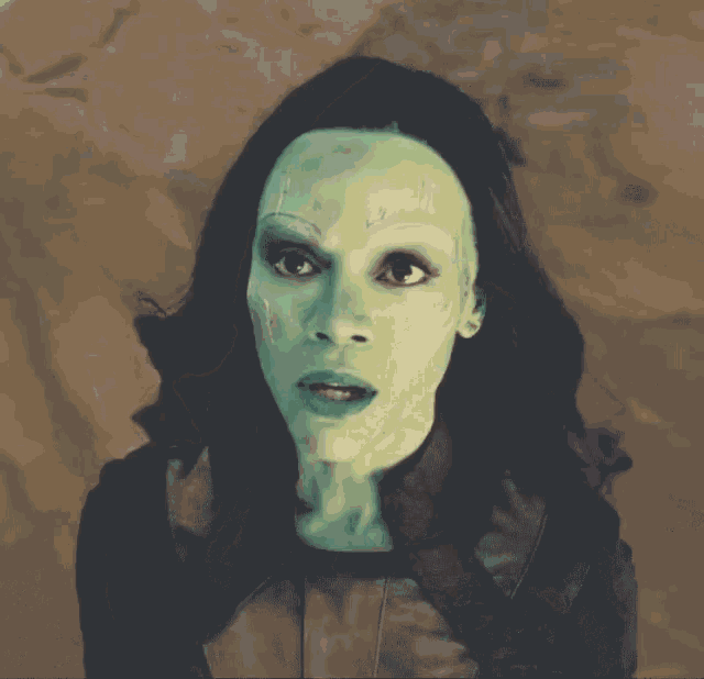 a close up of a woman 's face with green makeup