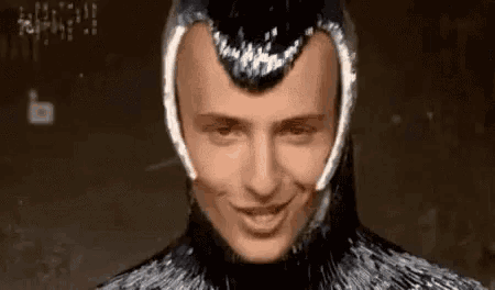 a close up of a man wearing a helmet and smiling at the camera .