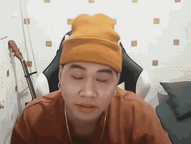 a man wearing a yellow hat is sitting in a chair