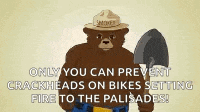 smokey the bear is holding a shovel and pointing at the camera while wearing a smokey hat .