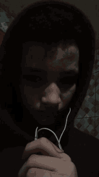 a person wearing a red hoodie is holding a pair of headphones