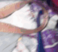 a blurry picture of a person wearing a purple and pink shirt