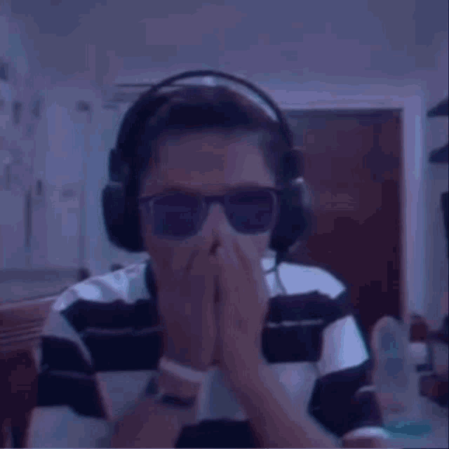 a young boy wearing headphones and neon sunglasses is sitting at a table .