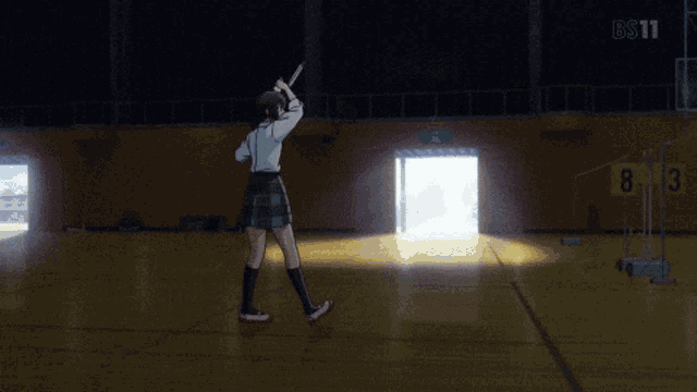 a girl in a school uniform is holding a badminton racquet in front of a bs11 logo